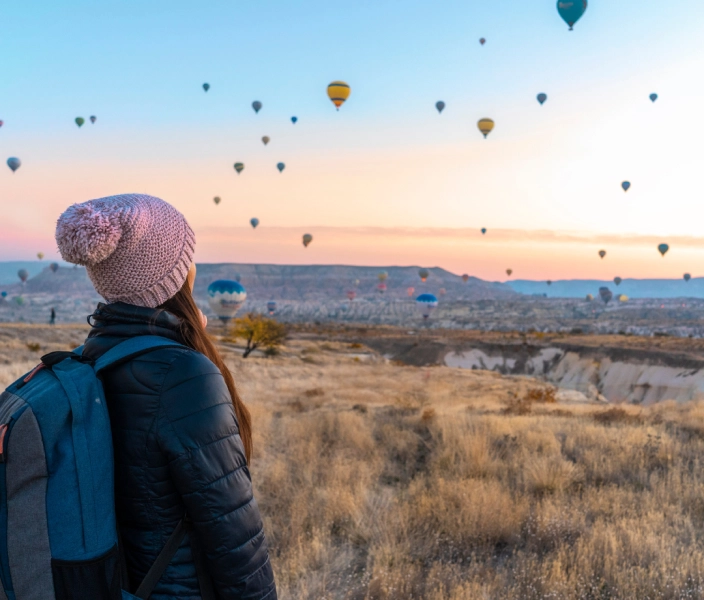 Travel Nurse looking at hot air balloons flying in the sky over the plains