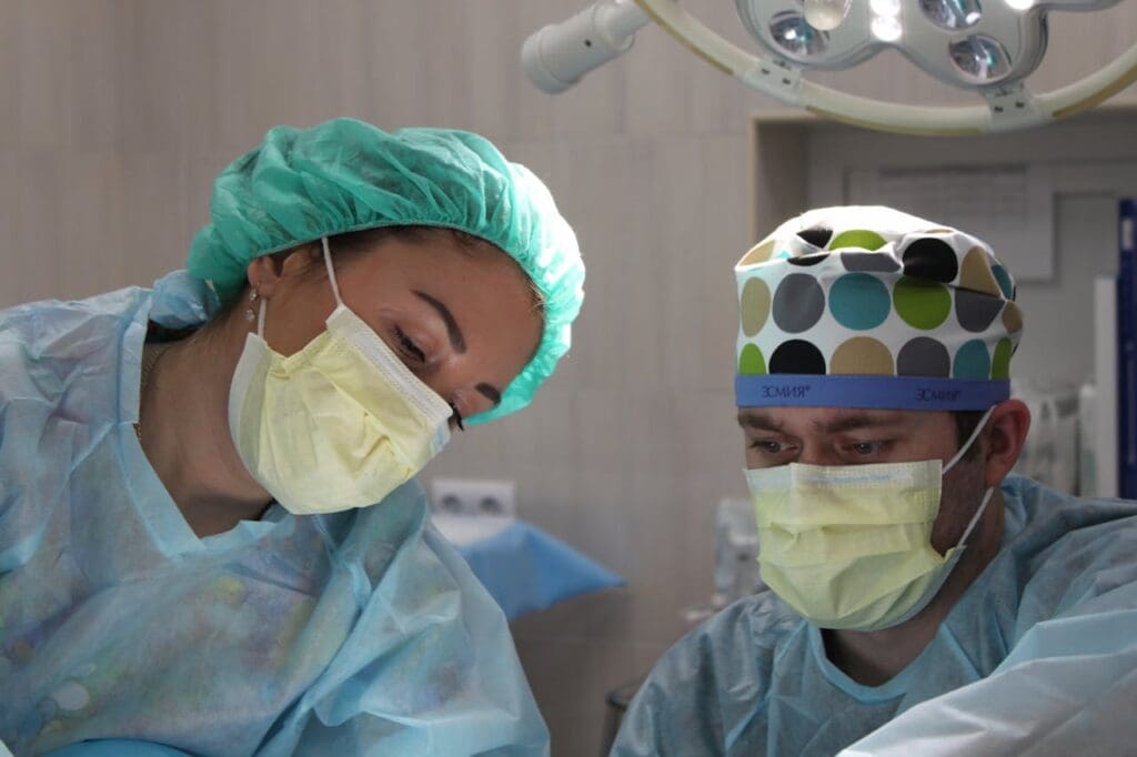 Two healthcare professionals in surgical attire working together, representing effective healthcare staffing in action.