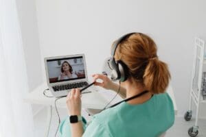 woman in scrubs on a video call with a patient to show the future of healthcare staffing